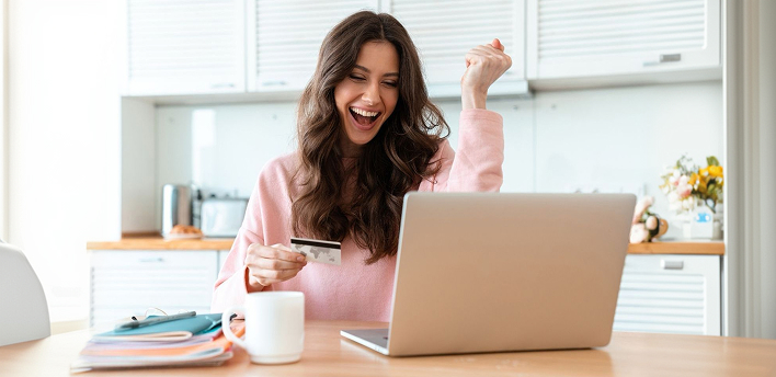 Happy woman celebrating at laptop